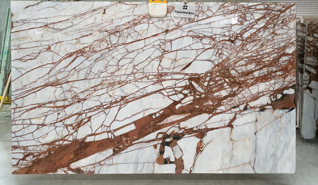 Slab of white marble with burnt red veining.