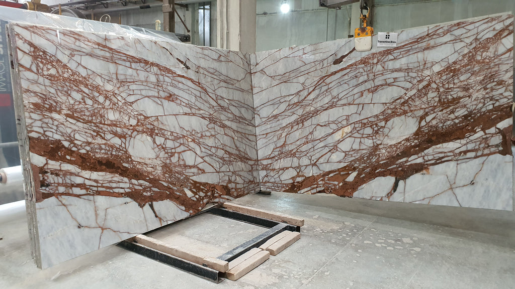 Book match of white marble with burnt red veining slabs.