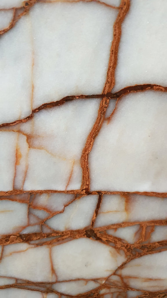 Close up of white marble with burnt red veining.